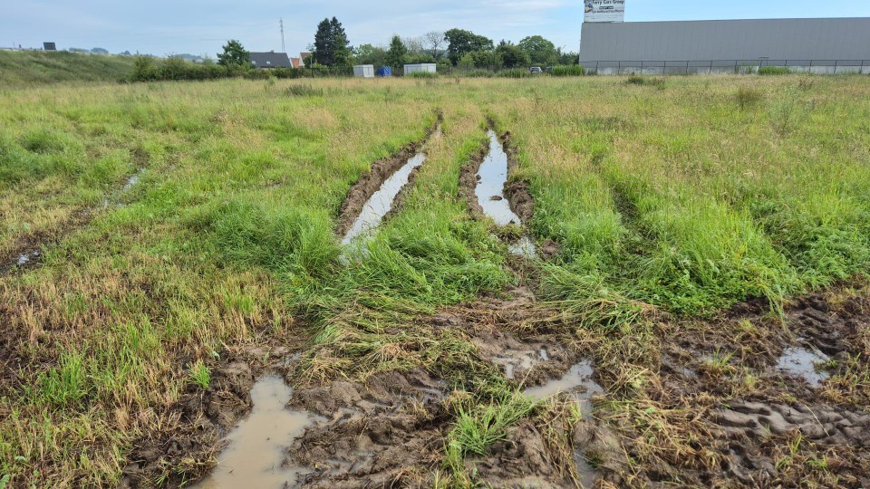 Bij een poging om het gras te maaien, trokken de voertuigen van de stadsdiensten diepe voeren in het drassige veld.