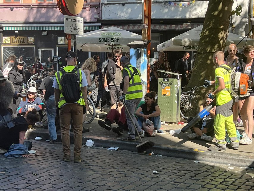 De schoonmakers stappen tussen de feestvierders.